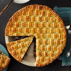 a pie on a plate with one slice cut out and two forks next to it