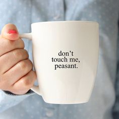 a woman holding a coffee mug with the words don't touch me, pesant