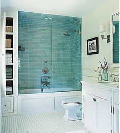 a white bathroom with blue tiles on the walls and floor is featured in an instagram