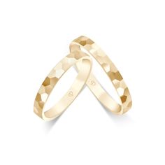 two yellow gold wedding bands with hearts on each side, set against a white background