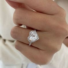 a woman's hand with a diamond ring on top of her finger and an engagement band