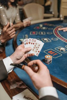 people playing cards at a casino table with their hands holding scissors and some other items