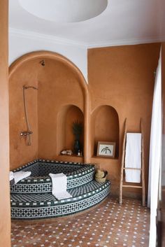 a bathroom with an orange wall and tiled flooring, including a circular bathtub