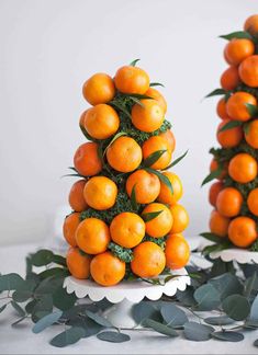 there are many oranges stacked on top of each other in the shape of trees