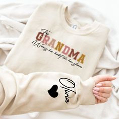 "I Wear My Heart On My Sleeve Mothers Day Sweatshirt, Custom Grandma Sweatshirt With Grandkid's Name on Sleeve, Mother Day Gift, Grandma Gift HOW TO ORDER 1 - Please check and review all listing photos. 2 - Please pick your t-shirt/sweatshirt/hoodie type and size. 3 -  Please pick your t-shirt/sweatshirt/hoodie color. 4 - Select the quantity. 5 - Click add to cart. 6 - Please click \"Continue to Payment\". PRODUCT INFORMATION ⭐ We have a size chart on our listing photos ⭐ All our simple color ones like White and Black are 100% Cotton ⭐ All our Heather Colors are cotton/polyester blend and they are super comfy soft! ⭐ Soft and High-Quality Fabric ⭐ Sueded Jersey ⭐ Pre-shrunk ⭐ Taped shoulder-to-shoulder ⭐ Tear away label ⭐ Side Seamed ⭐ Retail fit CARE INSTRUCTIONS ⭐ Inside out, wash with a Custom Text Long Sleeve T-shirt For Mother's Day, Custom Text Long Sleeve Tops For Gifts, Cotton Sweatshirt With Lettering For Gift, Personalized Long Sleeve T-shirt For Mother's Day, Long Sleeve T-shirt With Name Print Gift, Heart On My Sleeve, Grandma Sweatshirt, Mother Day Gift, Short Pj Set