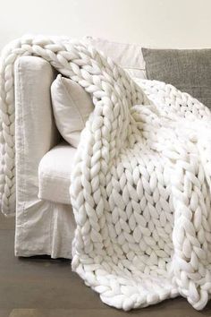 a white blanket sitting on top of a couch