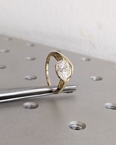 a diamond ring sitting on top of a piece of metal