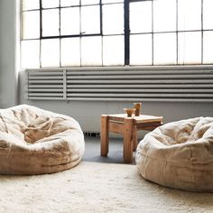 two bean bag chairs sitting on top of a white rug in front of a window