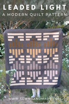 the finished quilt is displayed in front of some flowers and bushes with text overlay that reads