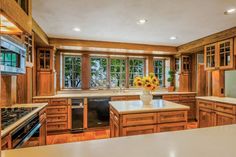 a large kitchen with wooden cabinets and white counter tops, an island in the middle