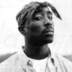 a black and white photo of a man with a bandana on his head looking off to the side