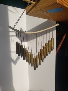 a wind chime hanging from the side of a wall with bells attached to it