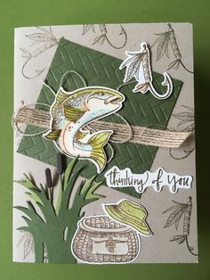 a close up of a card with a fish on it and some leaves in the background