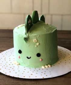 a green cake sitting on top of a white plate