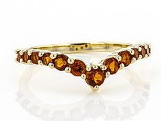 a yellow gold ring with three orange stones