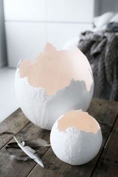 two white eggs sitting on top of a wooden table