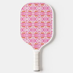 a pink and red patterned paddle on a white surface