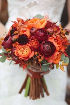 a bridal bouquet with orange and red flowers