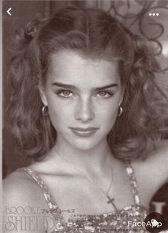 a black and white photo of a young woman with long hair wearing a sparky dress