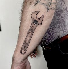 a man's arm with a wrench tattoo on it