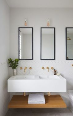 a bathroom with two sinks and mirrors on the wall