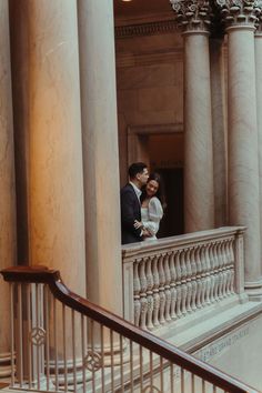 a bride and groom standing on the balcony of a building