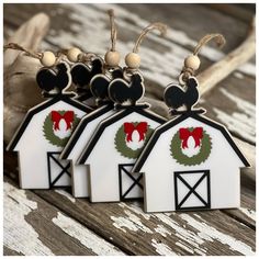 three barn shaped keychains with mickey mouse decorations on them, hanging from a rope