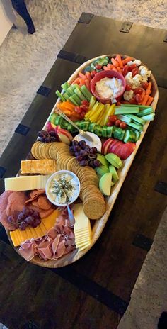 a platter filled with different types of cheeses and meats on a table