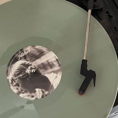 a record player with a black and white photo on the disc, next to a pair of scissors