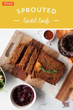 a wooden cutting board topped with meatloaf and cranberry sauce