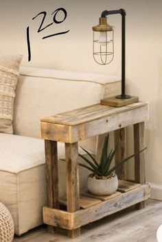 a living room with a white couch and wooden table next to a lamp on the wall