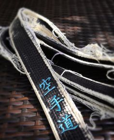 two black and white belts with writing on them