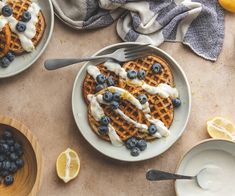 two waffles with blueberries, lemon and yogurt drizzled on them