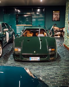 two green sports cars parked in a garage