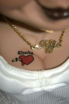 a close up of a person's chest with tattoos on it and the word chicky written in cursive font