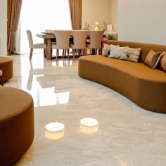 a living room filled with lots of furniture next to a dining room table and chairs