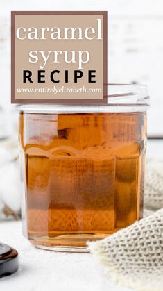 a jar filled with caramel syrup sitting on top of a table next to a cell phone