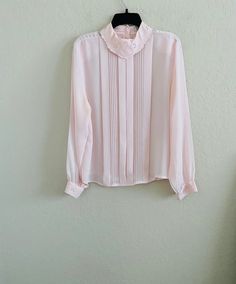 Vintage Karen Scott Blush Pink Chiffon Ballet High Collar Chiffon Blouse  Size 10 Excellent vintage condition  Polyester  Lie flat measurements: Length from shoulder: 25 inches  Shoulder to shoulder: 16 inches  Armpit to armpit: 22 inches Authentic  See all photos Long Sleeve Chiffon Blouse For Daywear, Pink Chiffon Top For Workwear, Flowy Pink Chiffon Blouse, Feminine Chiffon Blouse For Daywear, Vintage Sheer Blouse For Spring, Elegant Pink Chiffon Top, Vintage Pink Blouse For Formal Occasions, Feminine Sheer Blouse For Daywear, Pink Chiffon