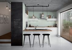 a kitchen with three stools and a chalkboard on the wall in front of it