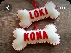 two dog bone ornaments with the word kona written on them hanging from a string