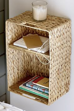 a wicker shelf with books and a candle