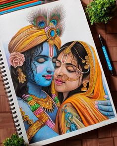 a drawing of two women hugging each other on a notebook with colored pencils next to it