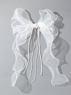 a white bow with pearls hanging from it's side