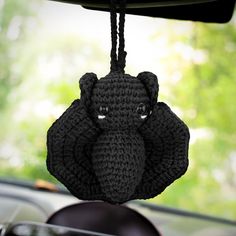 a crocheted elephant head hanging from the back of a car