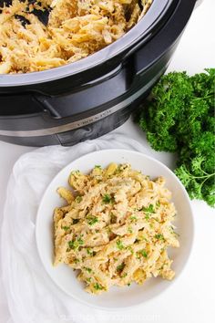 a bowl filled with food next to an open crock pot and broccoli