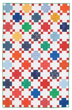 a colorful quilt is hanging on the wall in front of a white background with blue, green, red and yellow squares