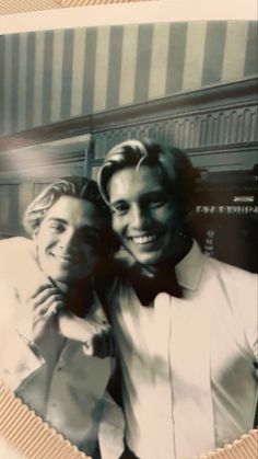 two men in tuxedos are posing for a photo with their hands on each other's shoulders