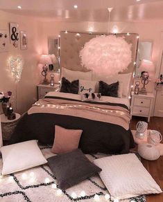 a bedroom decorated in pink, black and white with lights on the wall above the bed