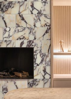 a room with a fireplace and marble tiles on the wall