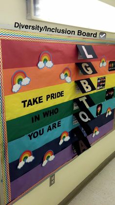 a bulletin board with rainbows, clouds and the words take pride in who you are